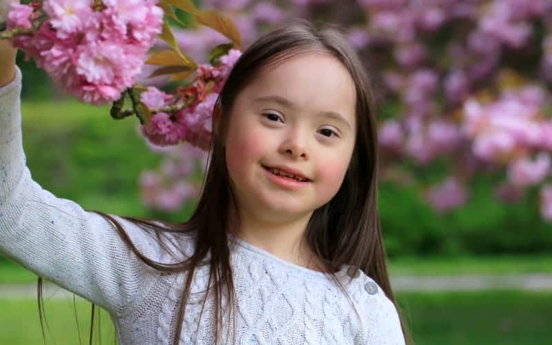 Young girl with Down Syndrome outside in the park