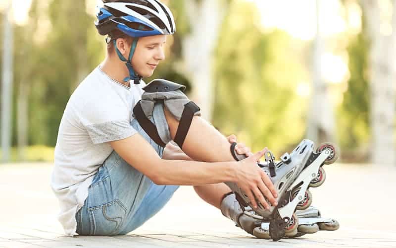 Teen boy adjusts his roller blade