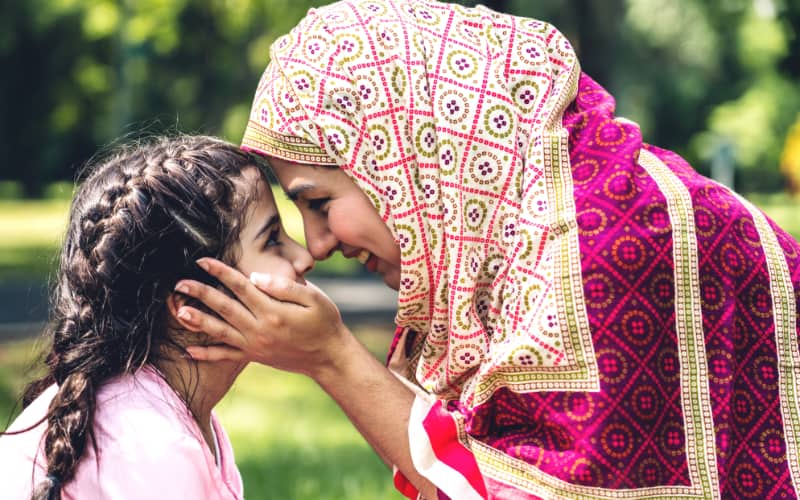 Muslim mother touches noses with her daughter