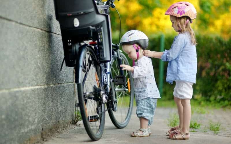 Two young sisters preparing to go bike riding