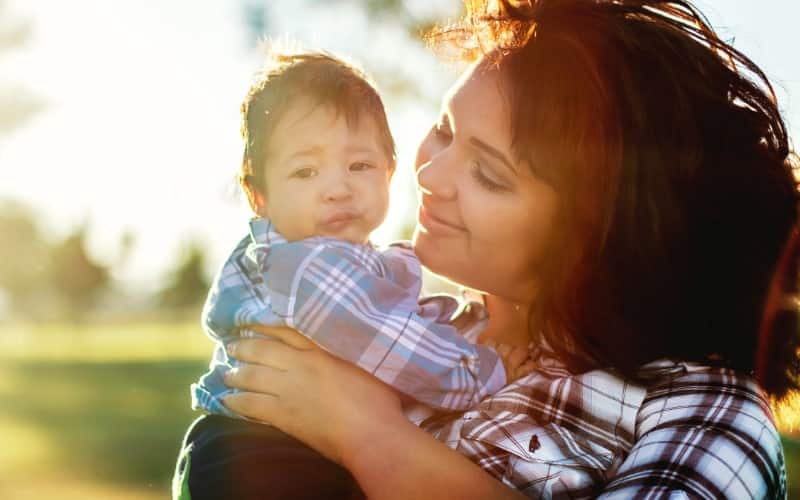 A mother smiles at her newborn