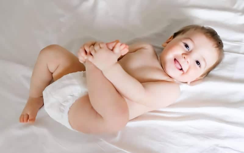 Smiling baby wearing a diaper